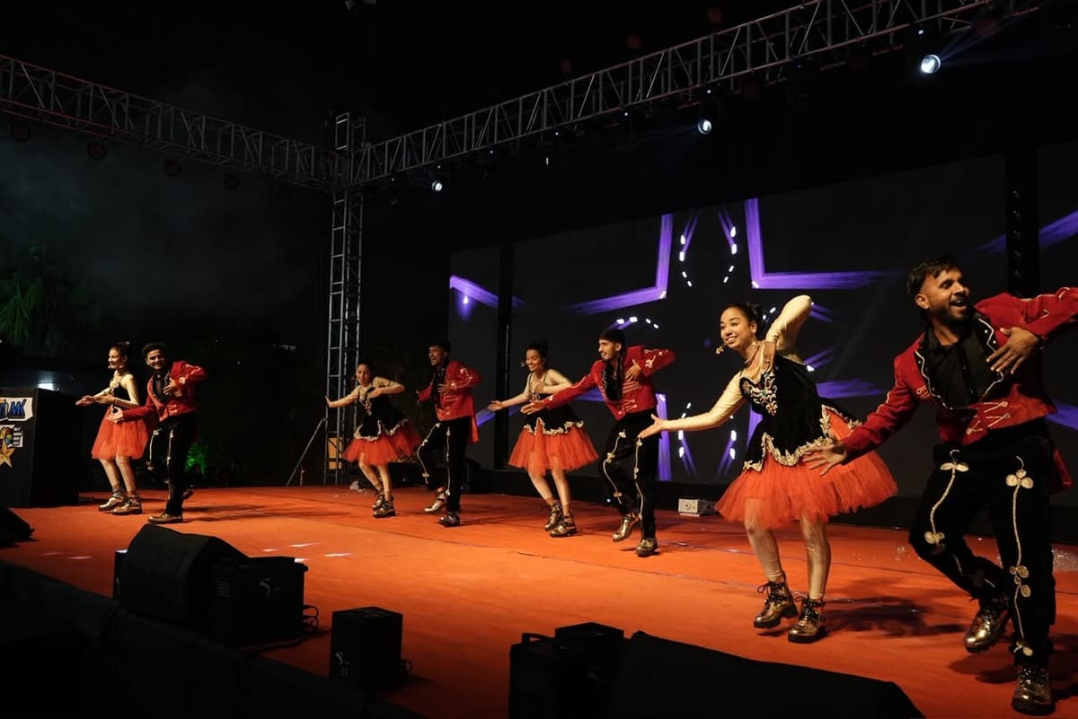 Dancers mid-performance under dramatic stage lighting at a corporate event